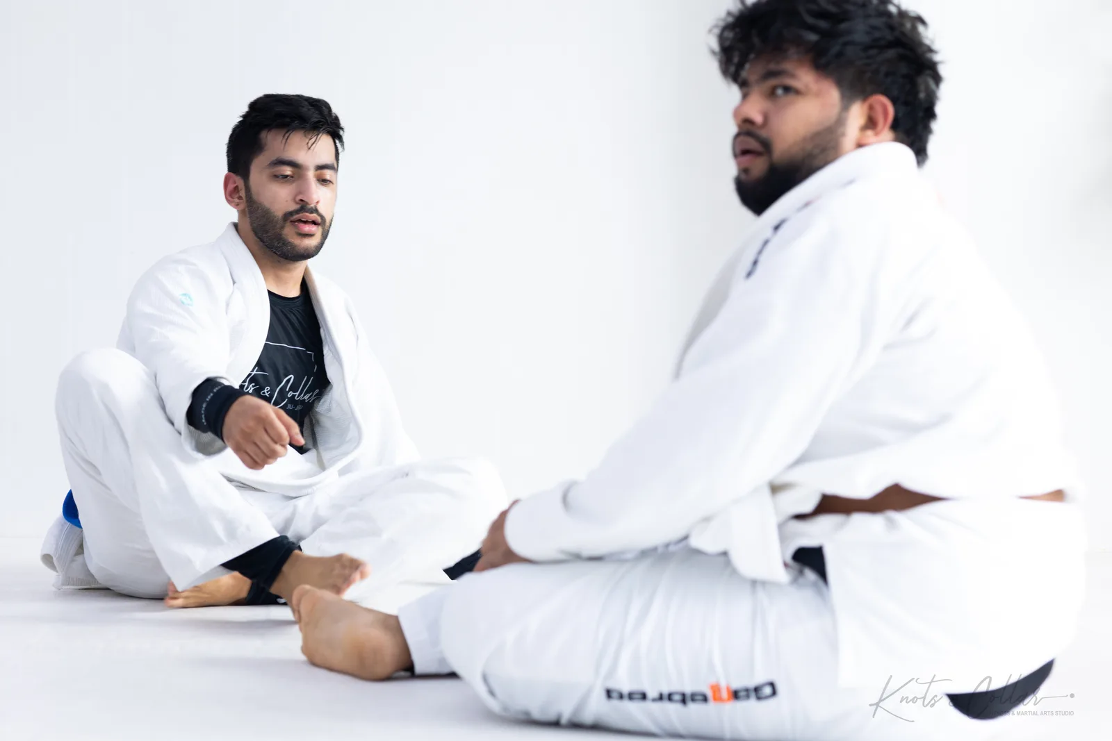 A jiu-jitsu instructor talking through a technique with a student during a one-on-one BJJ session at Knots & Collar, Defence Colony