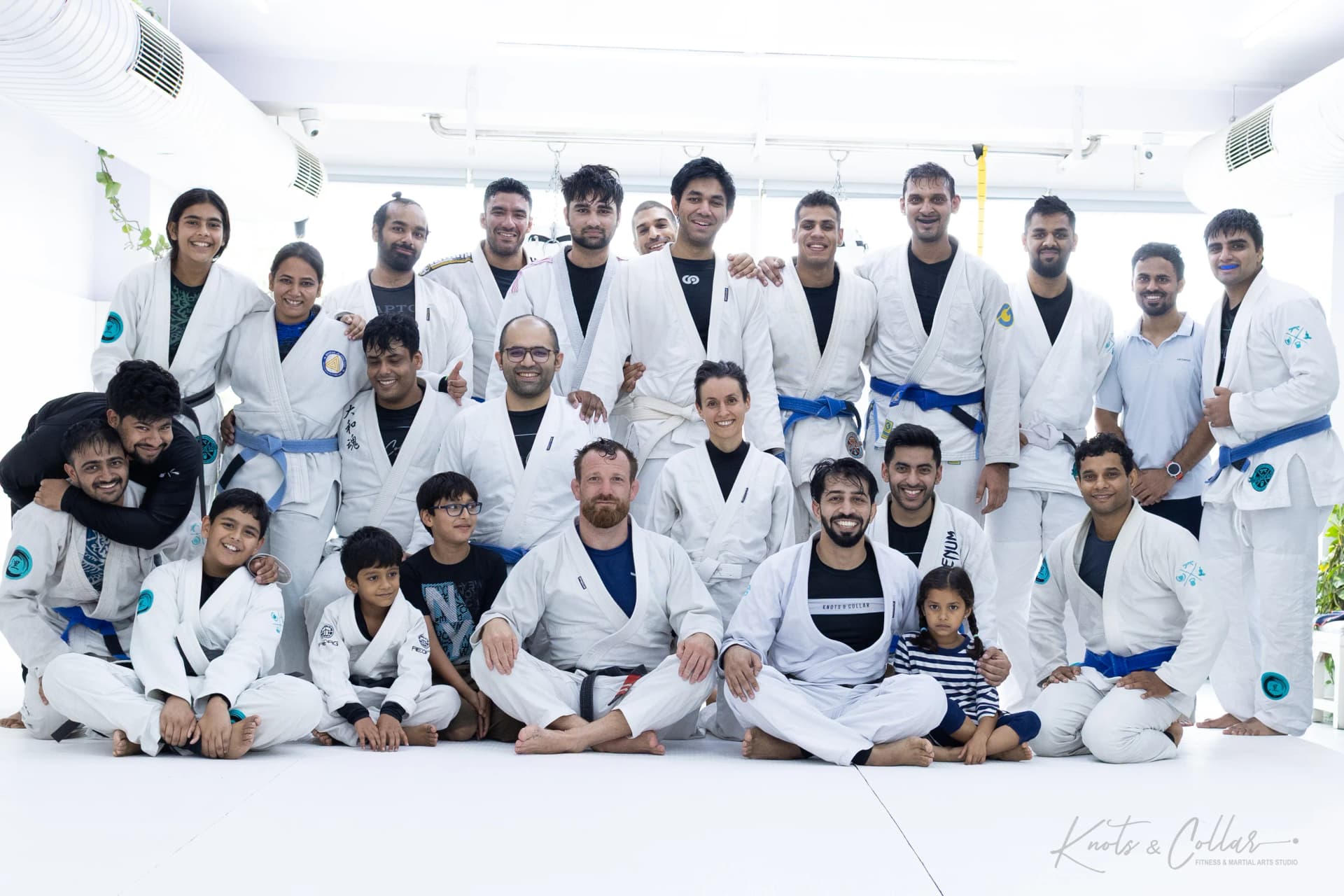Adults and children on the mat with a visiting black belt after a Jiu-Jitsu seminar at Knots & Collar, New Delhi