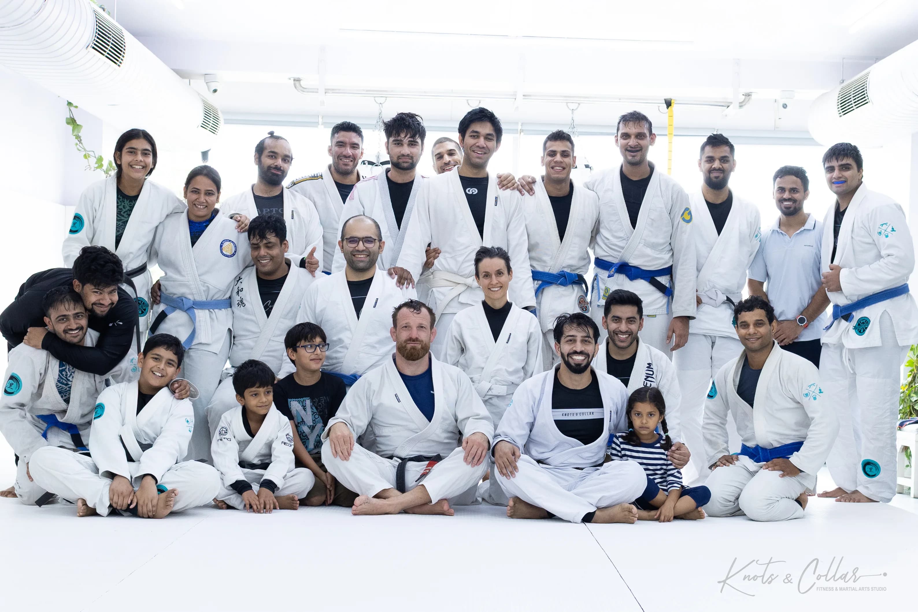 Adults and children on the mat with a visiting black belt after a Jiu-Jitsu seminar at Knots & Collar, New Delhi