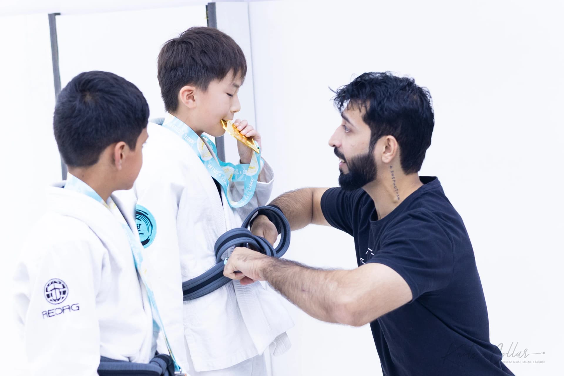 Professor Binish Sukhija awarding medals and bjj belts to kids at Knots and Collar BJJ class Defence Colony Delhi