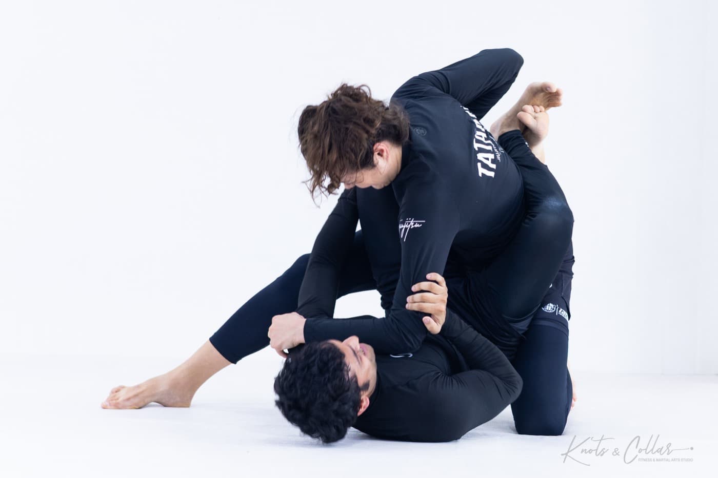 A woman controlling the top position in a no-gi roll at Knots & Collar, Defence Colony